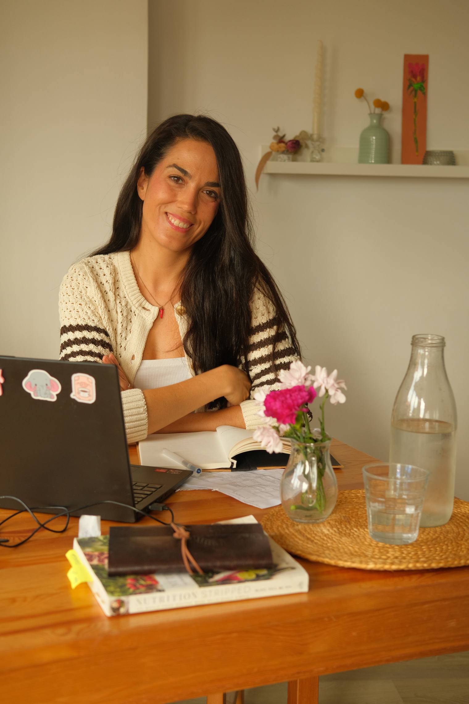 Laura García Moldón, nutricionista digestiva online, sonriendo en su mesa de trabajo