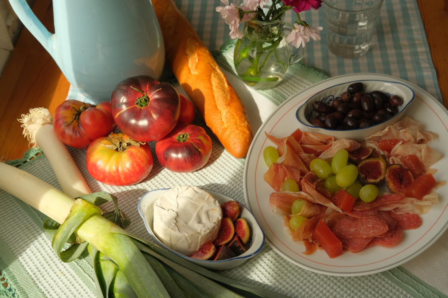Mesa con tomates, pan, quesos y frutas: alimentación variada sin miedo a la comida